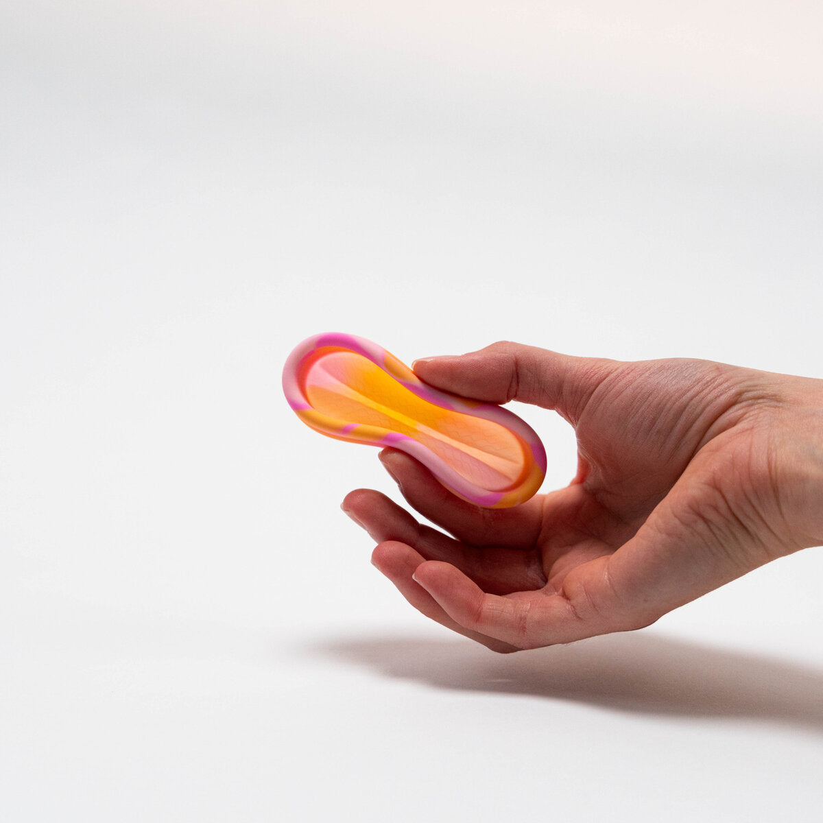 PERIOD DISK, flach zusammengedrueckt zwischen zwei Fingern